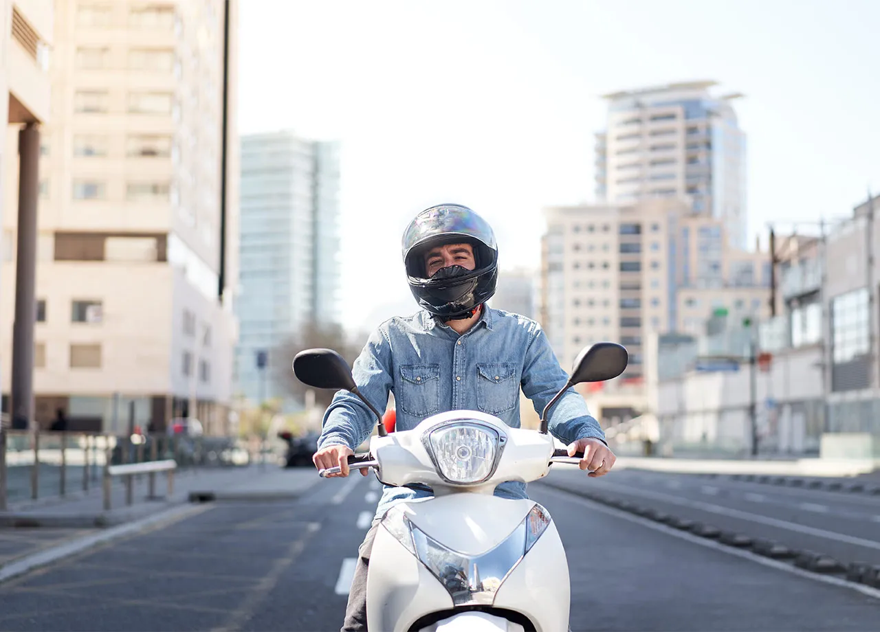 Ein junger Mann fährt mit einem 125 cm³ Roller. Führerscheinklasse A1